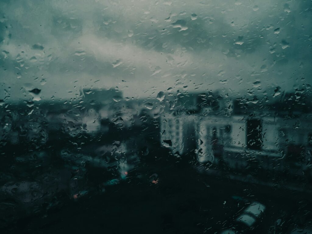The picture shows Kolkata’s grey monsoon skies and a couple of buildings taken from behind a glass window blurred by raindrops.