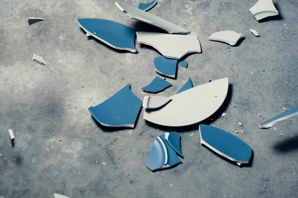 Image of a blue plate shattering as it hits the ground.