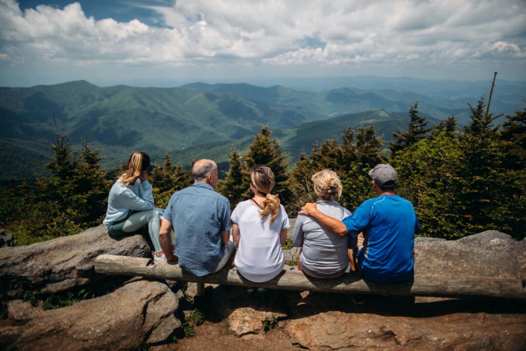 Image of a family on a mountain-top hike together. 