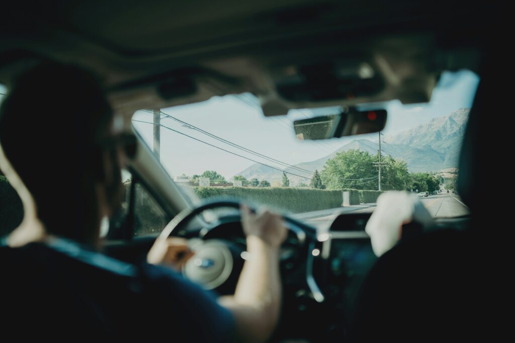 Two people driving down a road onlooking scenery