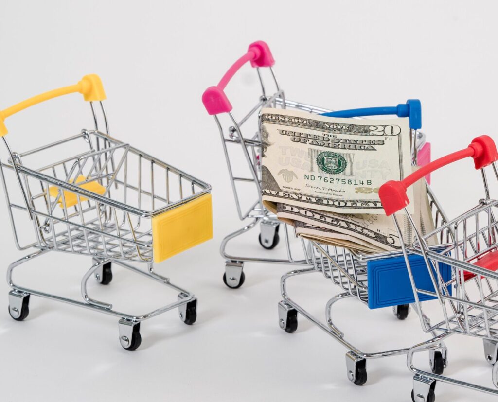 Colorful miniature shopping carts with US dollar bills.